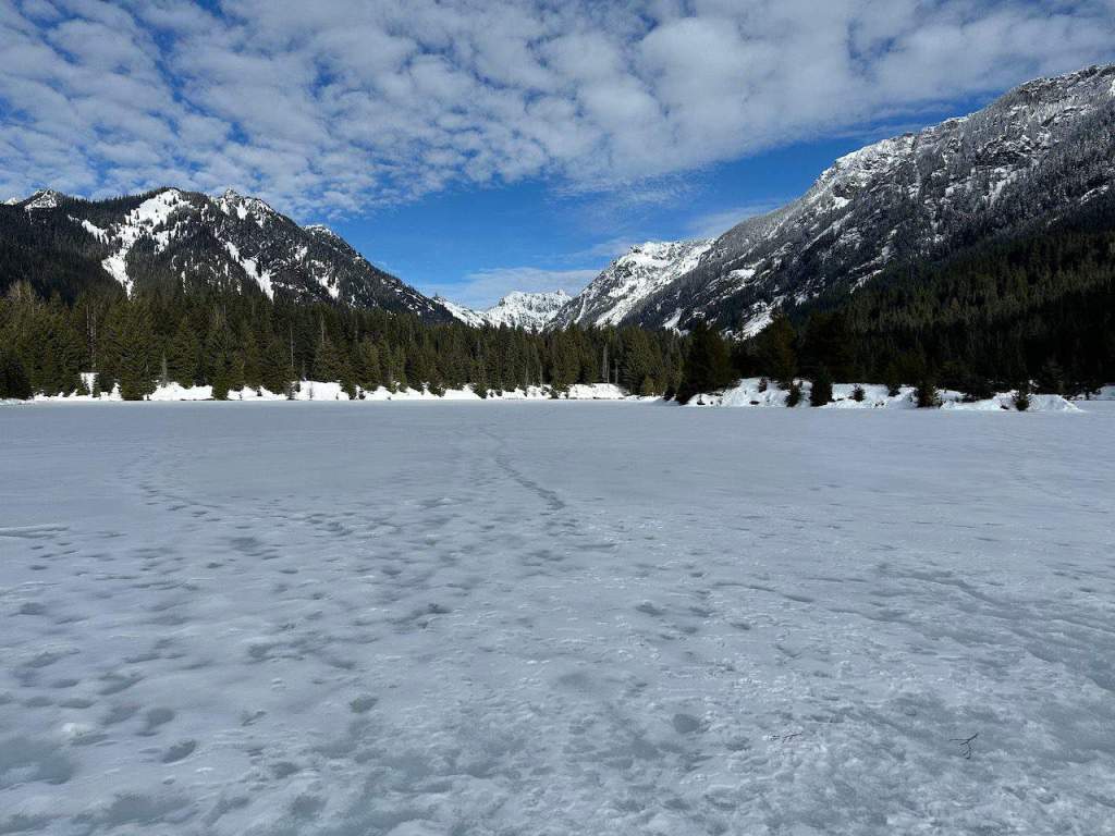 Gold Creek pond snowshoeing on a blue bird day with the mountains in the distance.  A great family hike for 