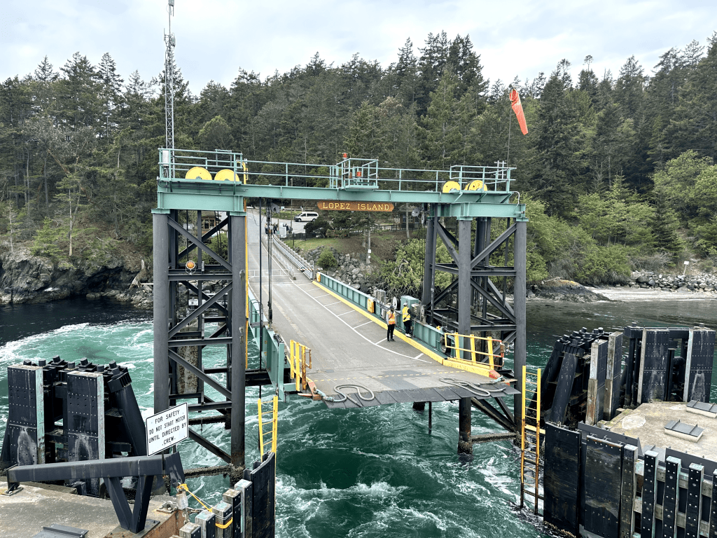 Lopez Island ferry terminal in lush natural setting with workers and safety features.