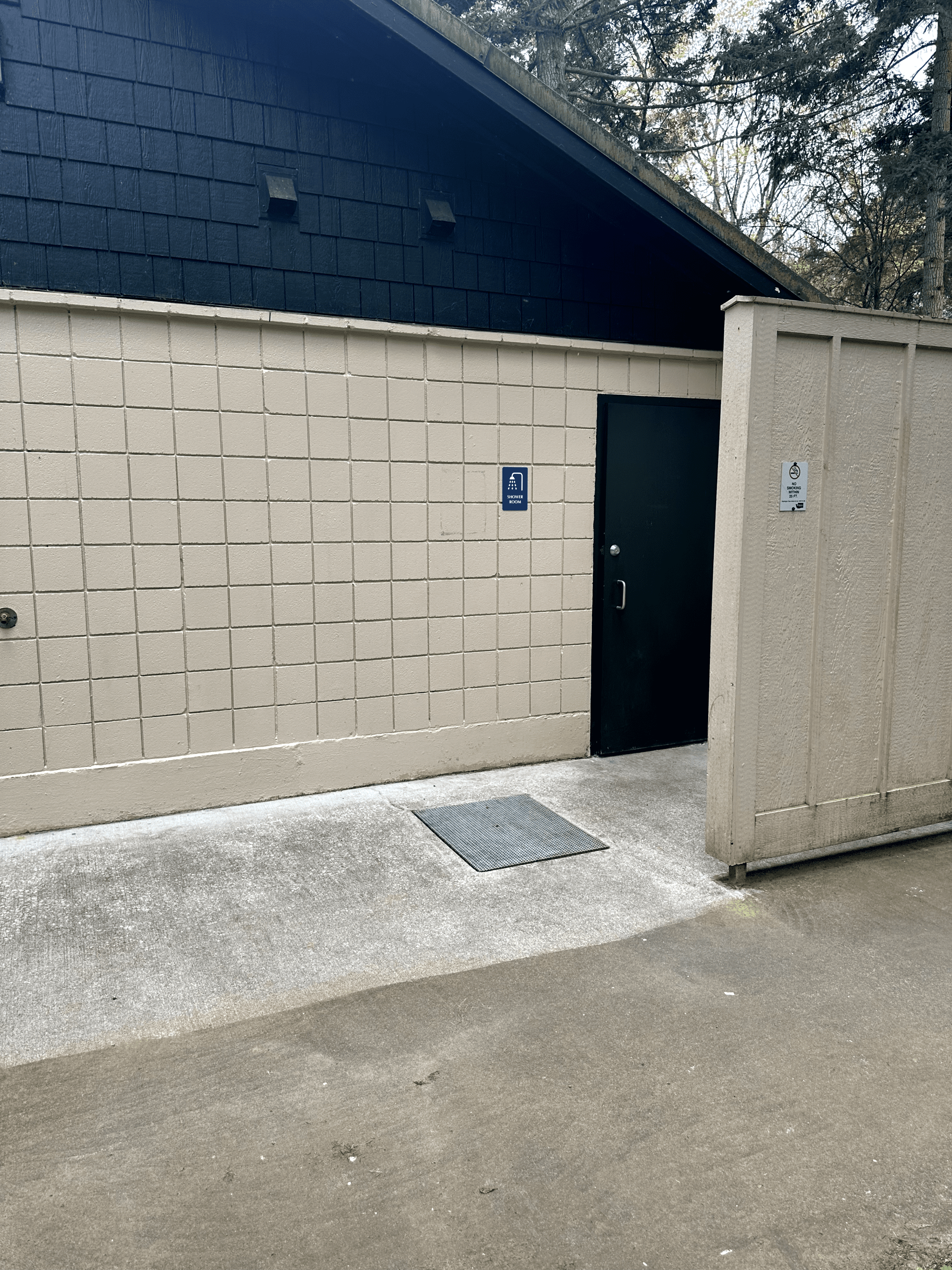 Beige utility building with wheelchair-accessible entrance in a park.