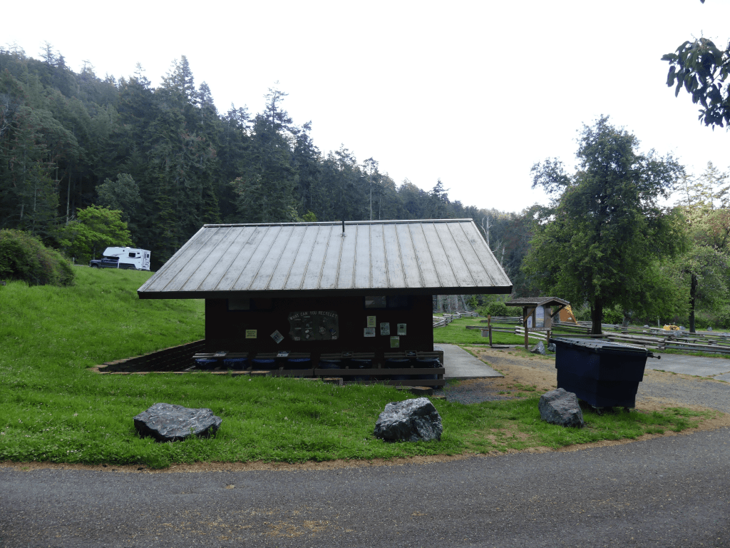Tranquil outdoor park pavilion in a forest setting with rustic charm and recreational RV.
